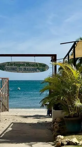 Entrada a un bar de playa en Santa Clara con el mar al fondo